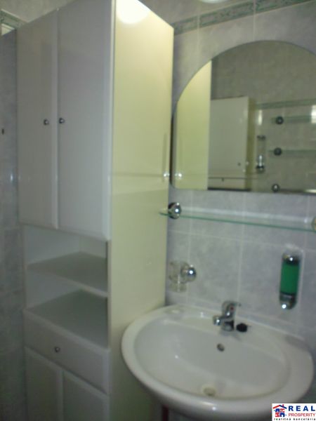 Badezimmer in einer 2-Zimmer-Wohnung mit Waschbecken, Spiegel und Schrank, ideal für Stauraum.