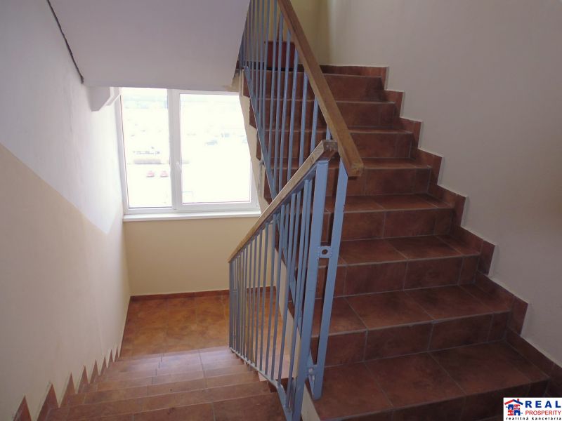 Eine Treppe mit Fenster und Geländer in einer 2-Zimmer-Wohnung.