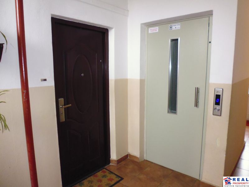 Eingang zur 2-Zimmer-Wohnung mit benachbartem Aufzug im Wohngebäude.