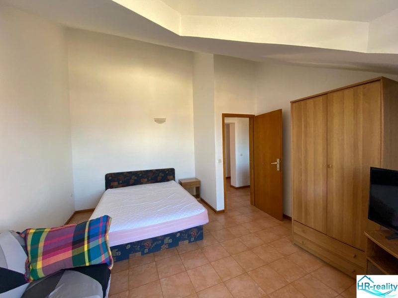 Schlafzimmer in einer Ferienwohnung mit Bett, Schrank und Fernseher.