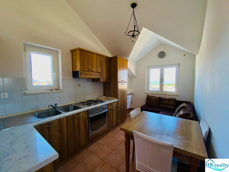 Küche mit Holzelementen, Esstisch und Sofa in einer Ferienwohnung.