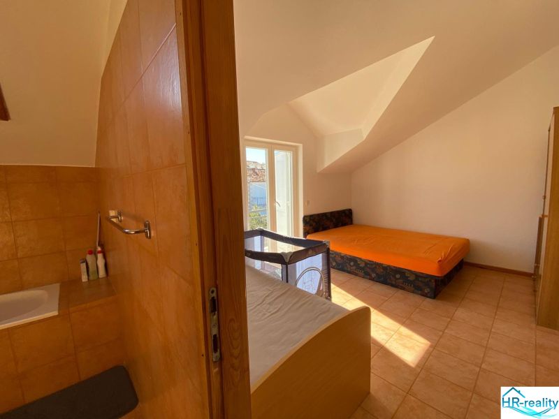 Interieur einer Ferienwohnung mit Sofa, Bett und Kinderbett.