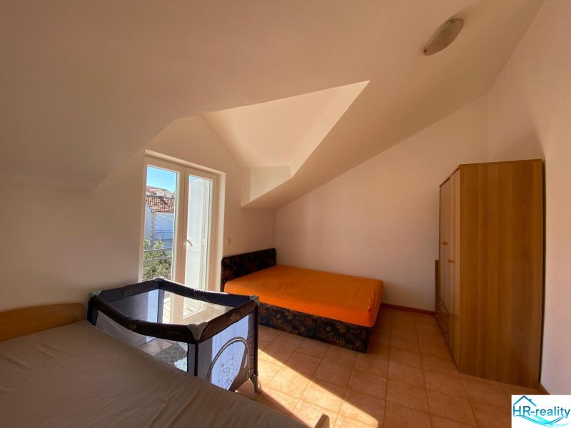 Schlafzimmer in der Ferienwohnung mit Betten, Schrank und Kinderbett.