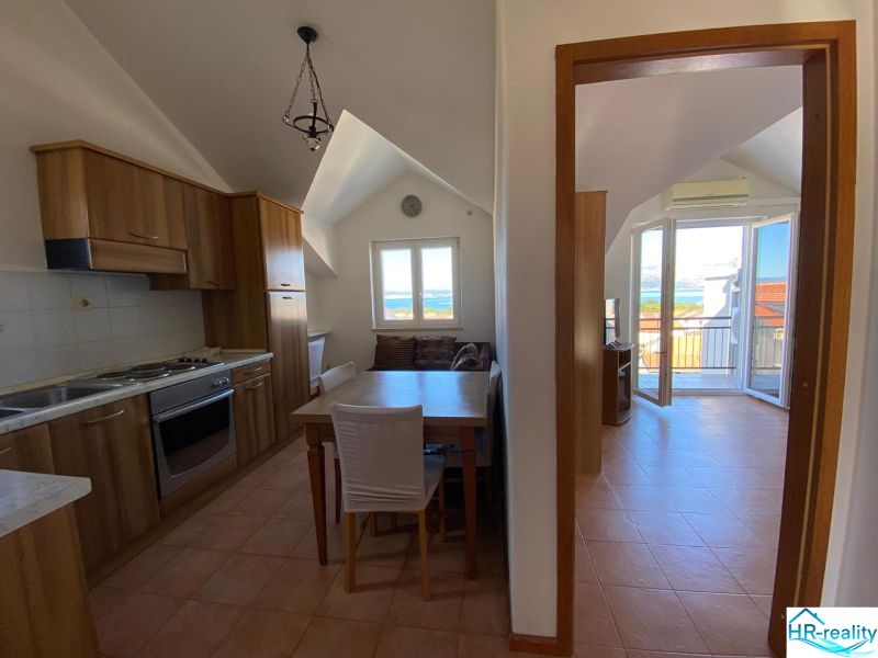 Die Küche der Ferienwohnung mit Holzschränken und Meerblick.