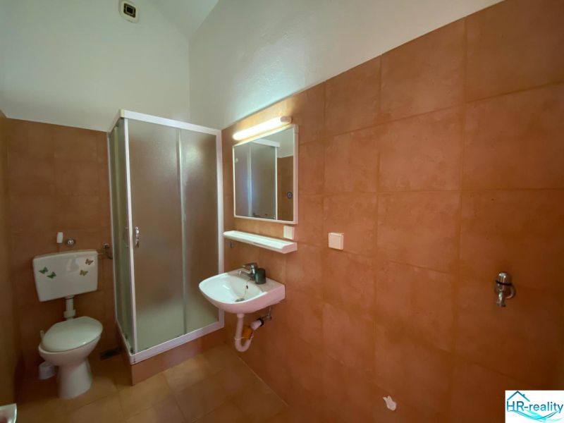 Badezimmer in einer Ferienwohnung mit Waschbecken und Duschkabine.