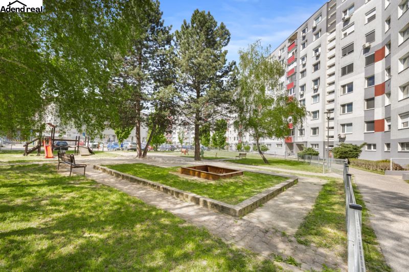 Ein Hof voller Grün mit Bänken und einem Sandkasten in der Kríkova-Straße, Bratislava - Vrakuňa.