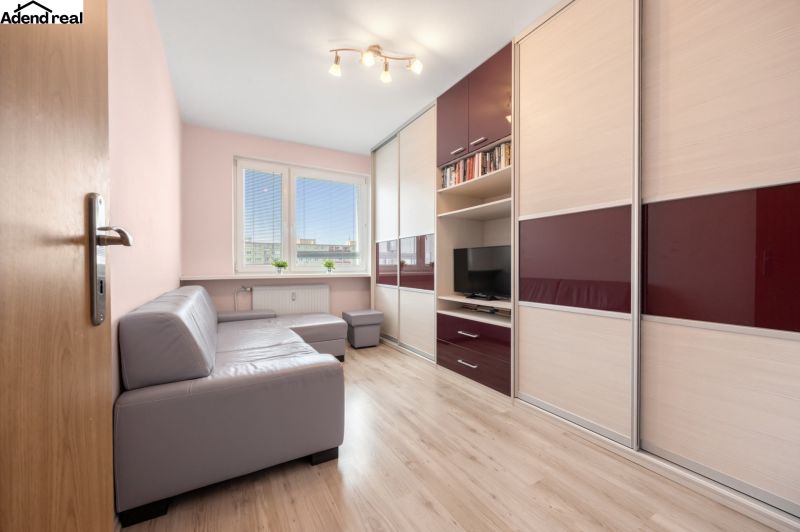 Wohnzimmer in einer 3-Zimmer-Wohnung mit Holzboden und Ecksofa.