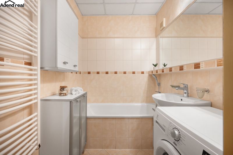 Badezimmer in einer 3-Zimmer-Wohnung mit Badewanne, Waschmaschine und Schrank.