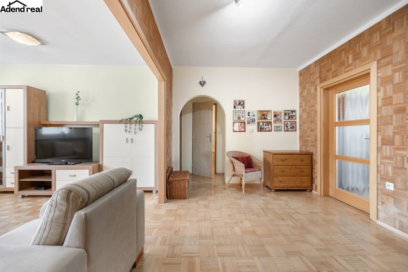 Wohnzimmer in einer 3-Zimmer-Wohnung mit Holzboden und Möbeln.