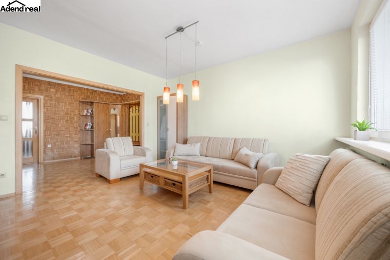 Wohnzimmer in einer 3-Zimmer-Wohnung mit Sofas und Holzboden.
