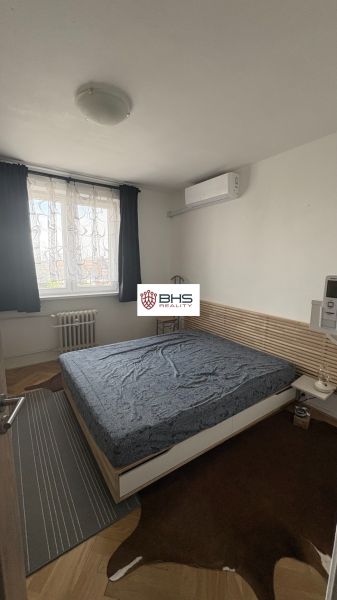Schlafzimmer in einer 2-Zimmer-Wohnung mit Teppichen auf dem Boden mit Holzdekor.