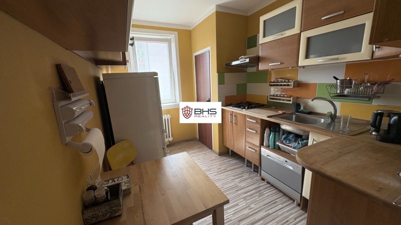 Küche einer 2-Zimmer-Wohnung, ausgestattet mit einer Küchenzeile und einem Boden in Holzoptik.