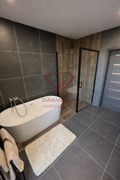 Ein Badezimmer in einem Einfamilienhaus mit freistehender Badewanne und Duschkabine.