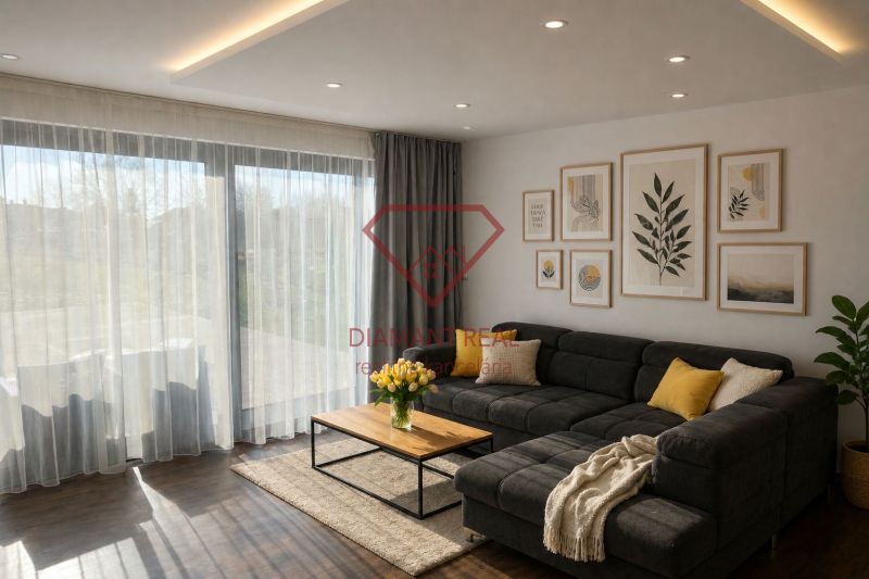 Wohnzimmer eines Einfamilienhauses mit Sofa, dekorativen Bildern und Bodenbelag in Holzoptik.