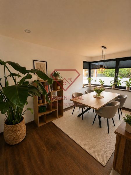 Esszimmer in einem Einfamilienhaus mit Holzelementen, Pflanzen und einem großen Fenster.