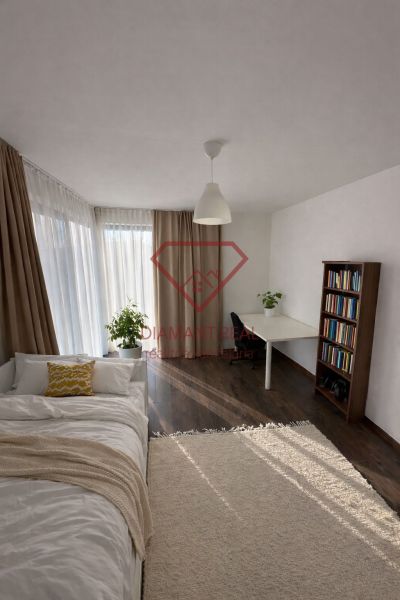 Innenraum eines Einfamilienhauses mit einem hellen Zimmer, einem Bett und einem Boden mit Holzdekor.