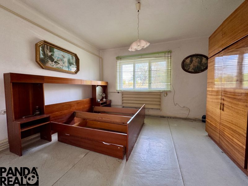Schlafzimmer in einem Einfamilienhaus mit Holzmöbeln und Kronleuchter.