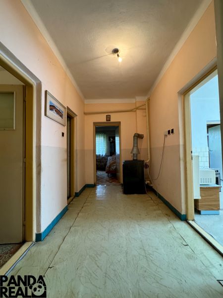 Der Flur in einem Einfamilienhaus mit einfacher Beleuchtung und älterem Innendesign.