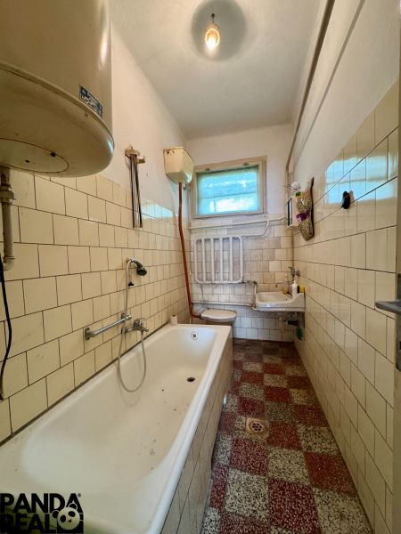 Badezimmer in einem Einfamilienhaus mit Badewanne, Waschbecken und Fliesen.