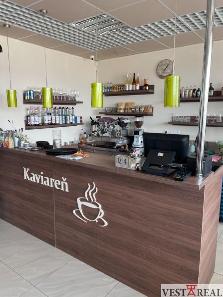 Interieur eines Cafés mit Holzelementen, Theke, Regalen und Kaffeemaschine, optimiert für Gastronomiebereiche.