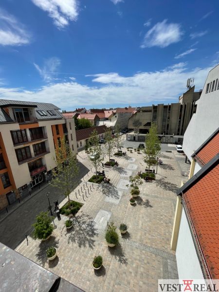Blick auf den Dreifaltigkeitsplatz in Trnava, mit Gastronomiebereichen und Grünflächen.