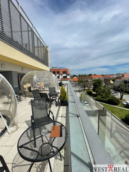 Terrasse am Dreifaltigkeitsplatz in Trnava mit Sitzgelegenheiten in Gastronomiebereichen.