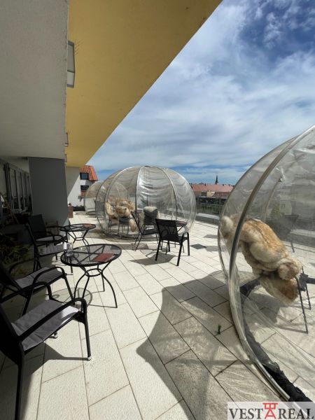 Terrasse in Trnava auf dem Dreifaltigkeitsplatz mit Gastronomiebereichen und durchsichtigen Kuppeln.