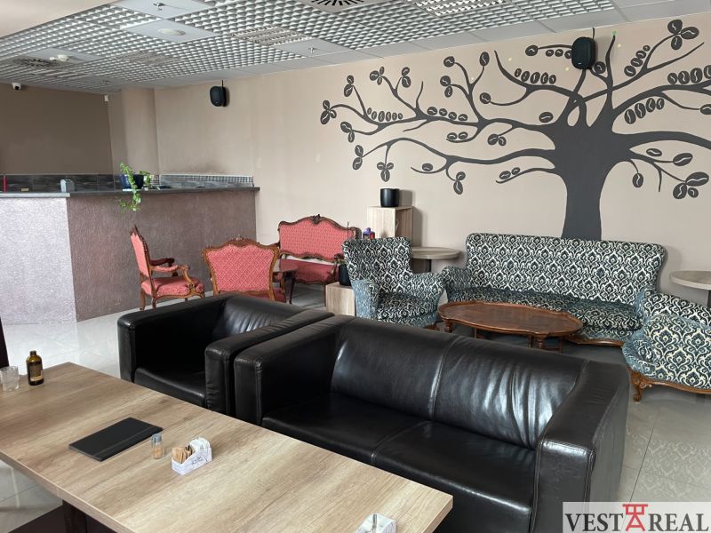 Gasträume mit Ledersesseln, gemusterten Sofas und Wanddekorationen.
