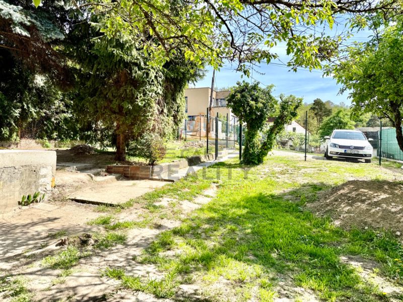 Ein Garten mit Gras und Bäumen bei einem Einfamilienhaus in der Straße Podkerepušky in Bratislava - Záhorská Bystrica.