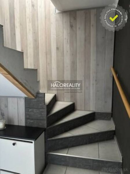 Treppe mit Holzverkleidung und Fliesen in einem Einfamilienhaus.