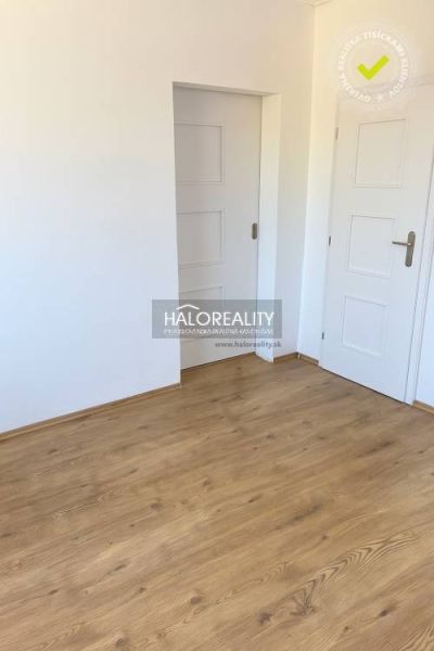 Innenraum eines Einfamilienhauses mit weißen Türen und einem Boden in Holzoptik.