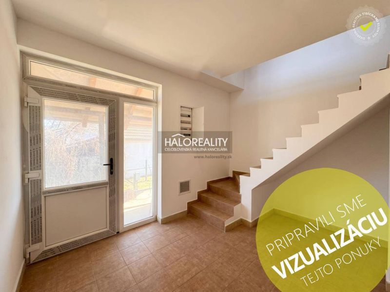 Innenraum eines Einfamilienhauses mit Treppe, Fliesen und Glastüren.
