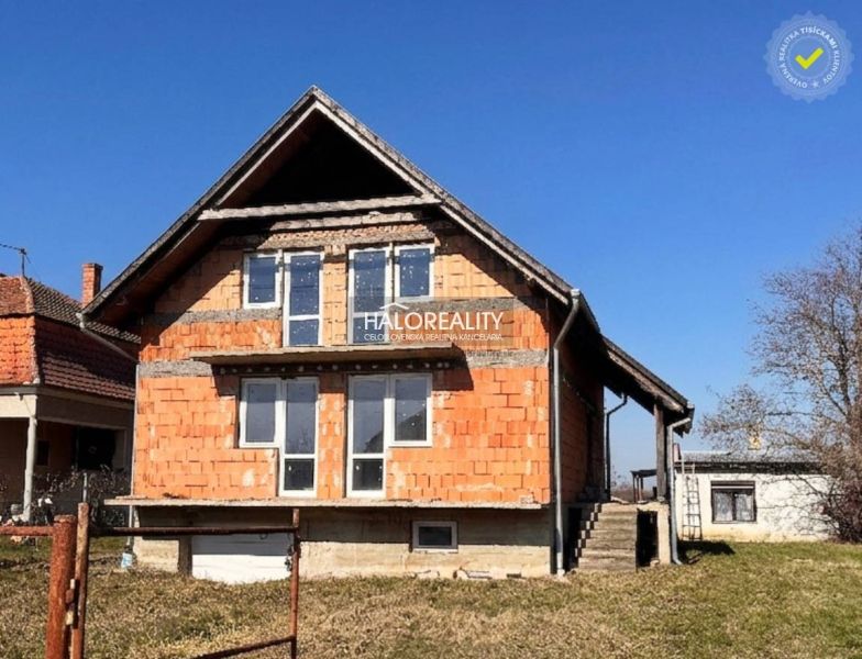 Ein Einfamilienhaus in Radvaň nad Dunajom mit unvollendeter Fassade und großen Fenstern.