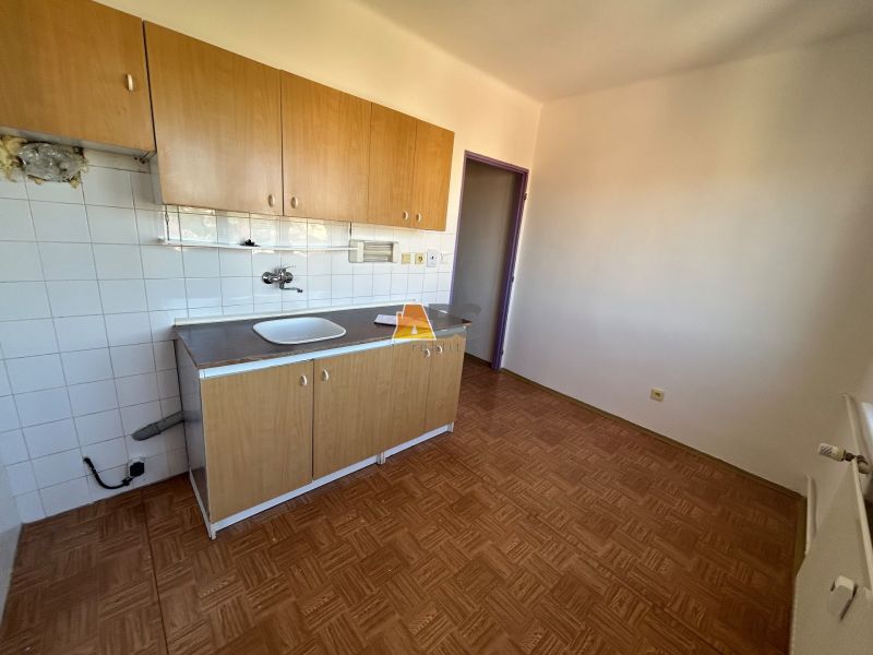Küche in einer 2-Zimmer-Wohnung mit Holzboden und Küchenzeile.
