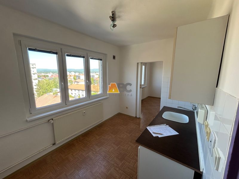 Küche in einer 2-Zimmer-Wohnung mit hellen Wänden und einem Boden in Holzoptik.