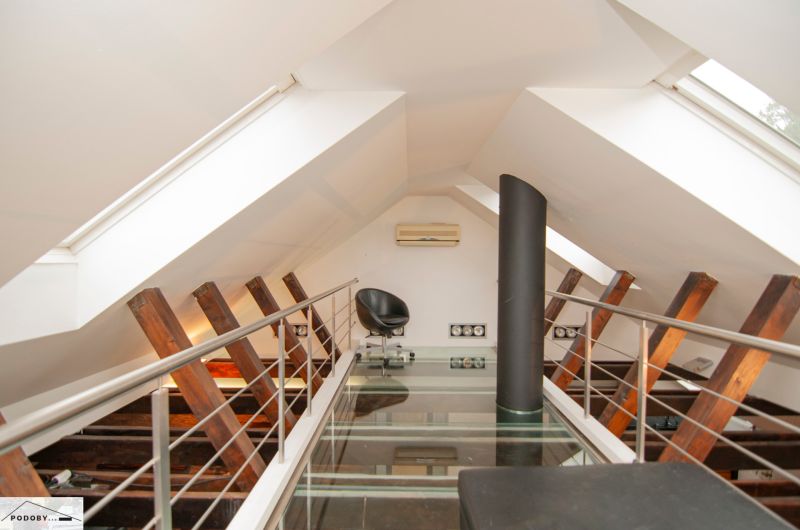 Dachbodenraum mit Glasboden, Sessel und Klimaanlage in einer 3-Zimmer-Wohnung.