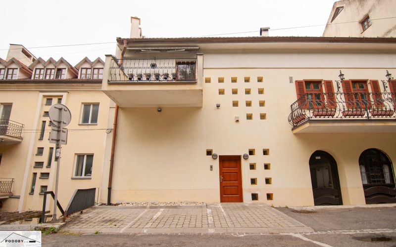 Fassade des Gebäudes mit Balkonen und Parkplatz vor dem Eingang.