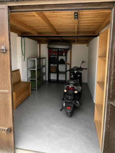 Garagen mit Motorrad, Holzdecke und Regalen zur Lagerung.
