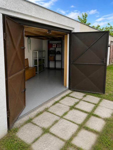 Offene Garagen in Nové Zámky mit Regalen und Betonweg.