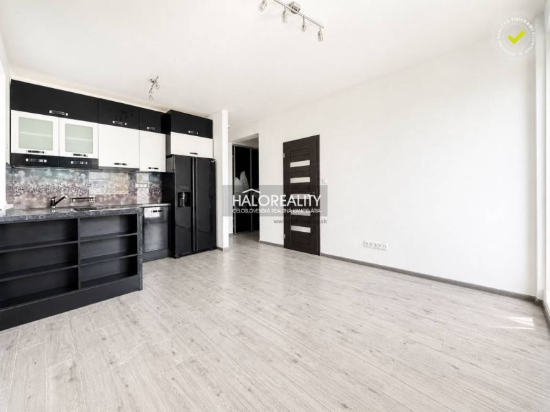 Küche in einer 2-Zimmer-Wohnung mit eingebauten Geräten und einem Boden in Holzoptik.