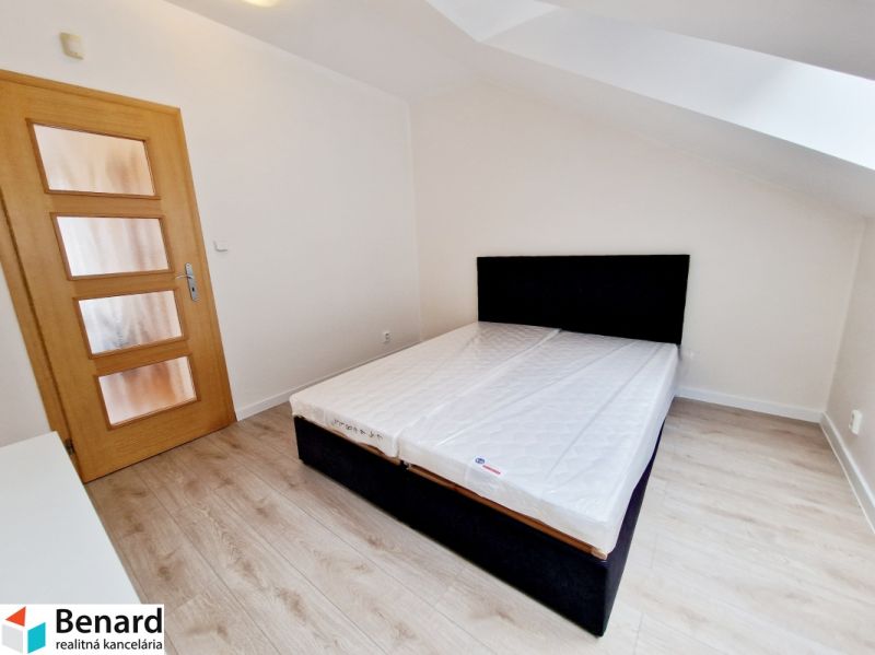 Schlafzimmer in einer 3-Zimmer-Wohnung mit Holzboden und einfachem Bett.