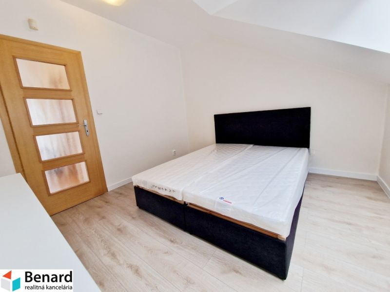 Schlafzimmer mit Holzboden in einer 3-Zimmer-Wohnung, einfaches Bett.