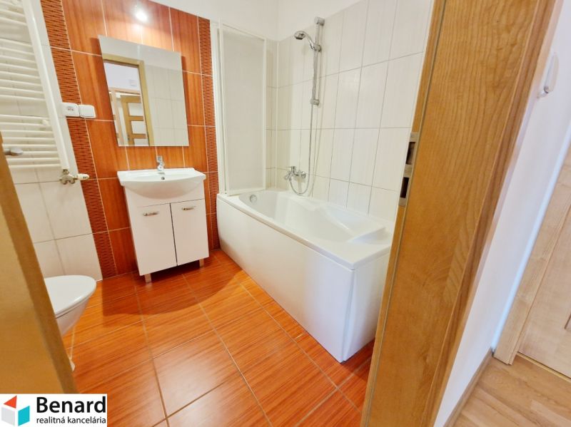Badezimmer in einer 3-Zimmer-Wohnung mit Badewanne und Waschbecken, Boden mit Holzdekor.