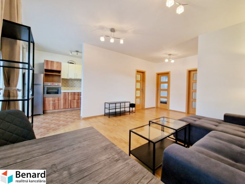 Wohnzimmer in einer 3-Zimmer-Wohnung mit grauem Sofa und Boden in Holzoptik.