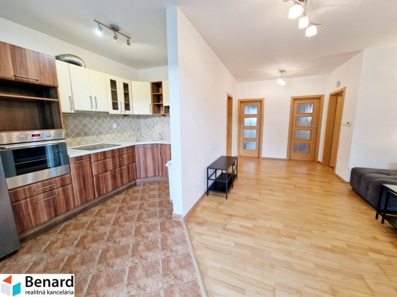 Küche in einer 3-Zimmer-Wohnung mit eingebauten Geräten und einem Boden in Holzoptik.