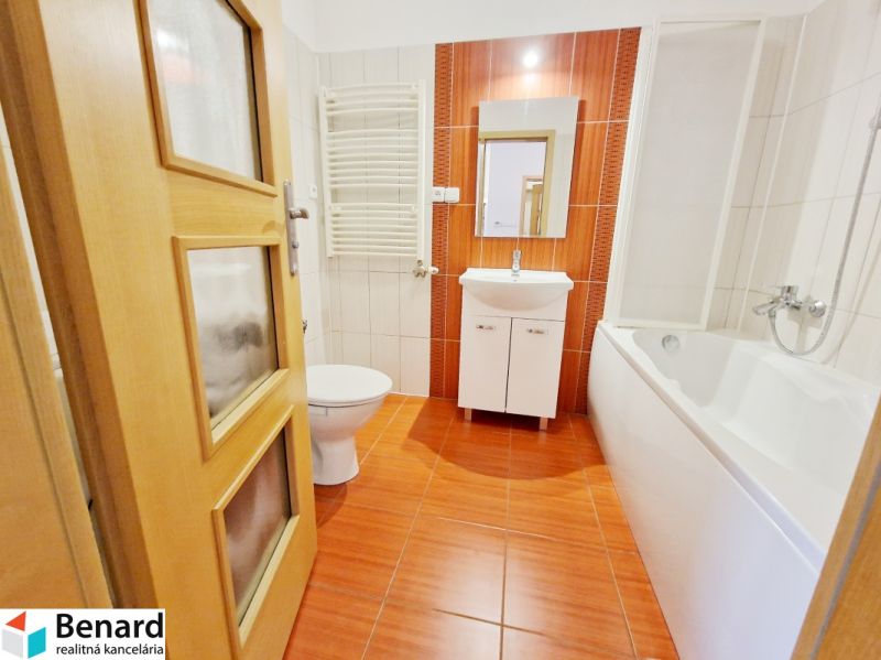 Badezimmer in einer 3-Zimmer-Wohnung mit Badewanne, Waschbecken und orangefarbenen Fliesen.