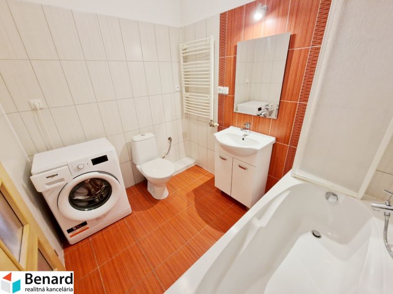 Badezimmer in einer 3-Zimmer-Wohnung mit Dusche, Waschmaschine und orangefarbenen Fliesen.