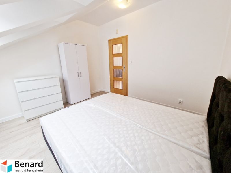 Schlafzimmer mit Bett, Kleiderschrank und Holzboden in einer 3-Zimmer-Wohnung.