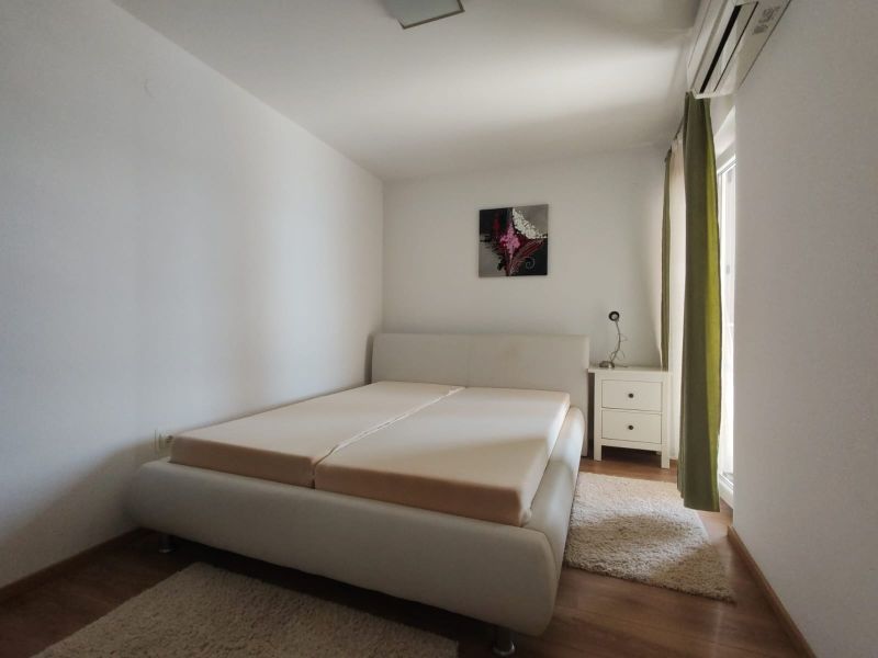 Helles Schlafzimmer in einem Einfamilienhaus mit Bett und Holzboden.