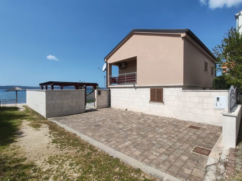 Ein Einfamilienhaus in Bibinje mit Terrasse am Meer und gepflastertem Hof.
